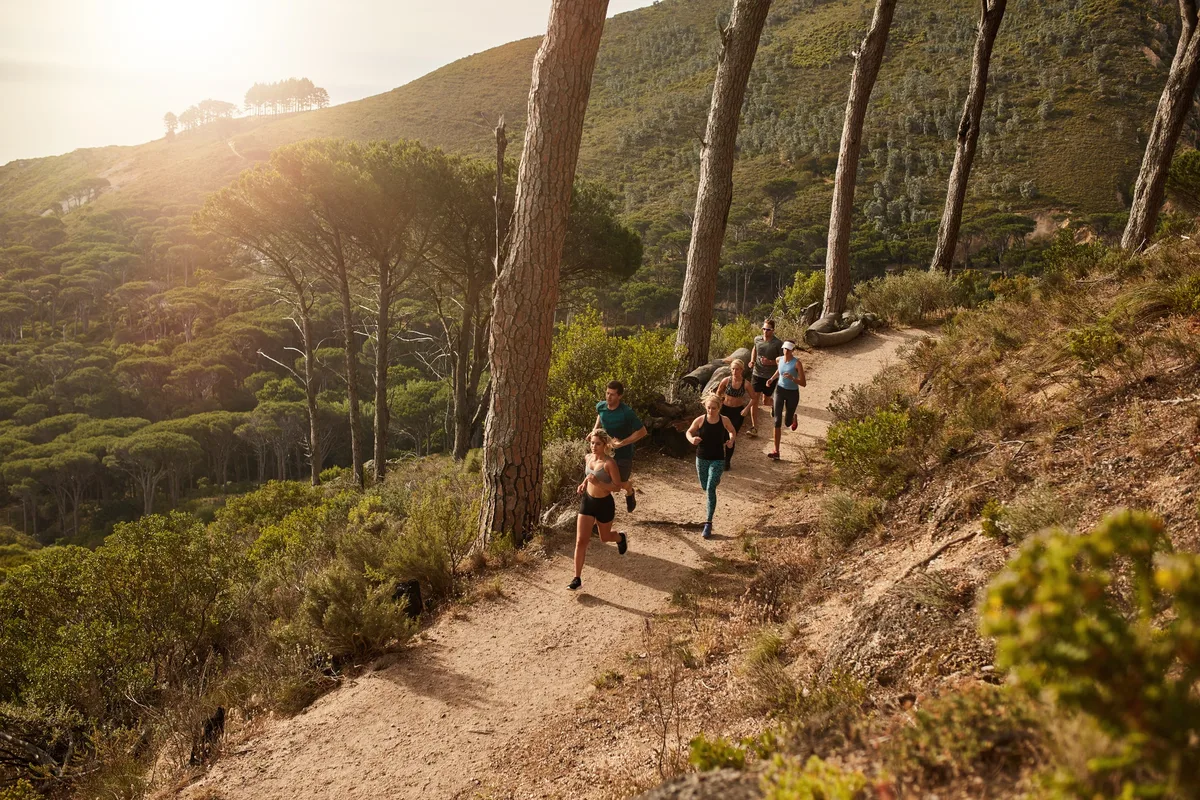 Group of athletes running on mountain path.