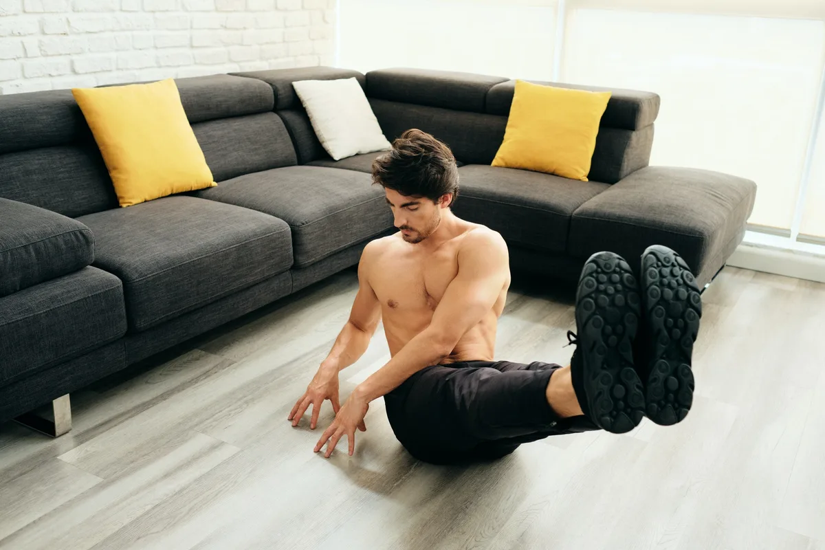 Adult Man Training ABS Muscles At Home Doing Russian Twist Exercise