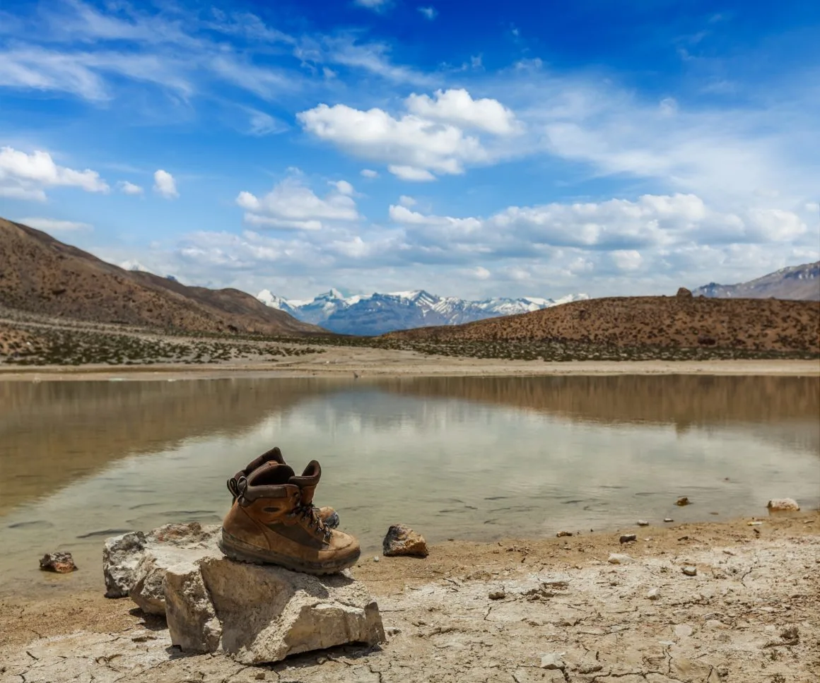 Trekking hiking boots at mountain lake in Himalayas
