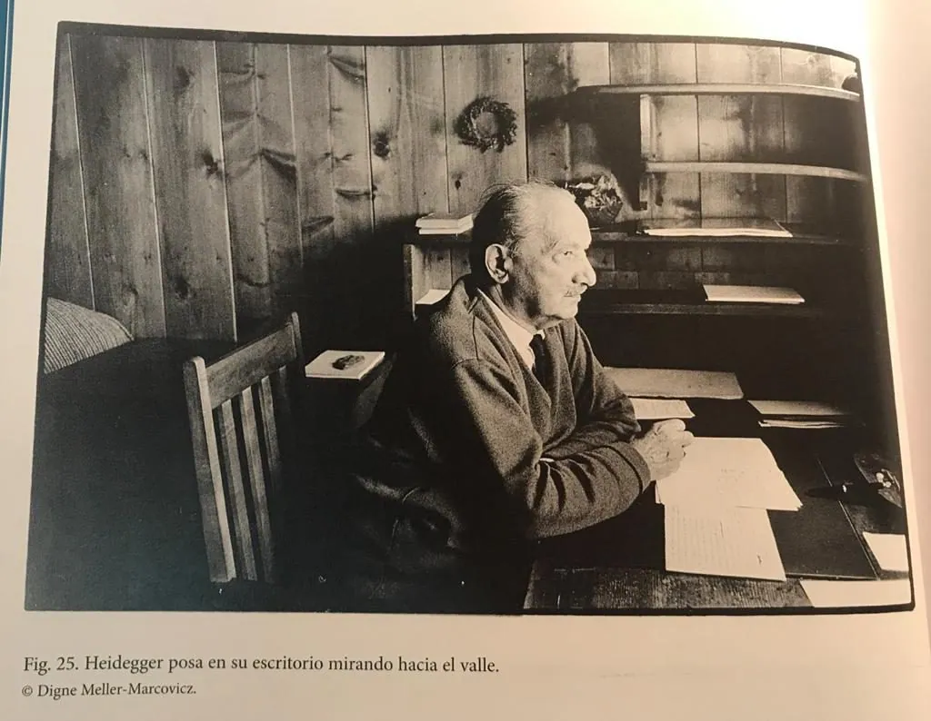 Reproducción de una fotografía de Heidegger sentado ante un escritorio en la cabaña.