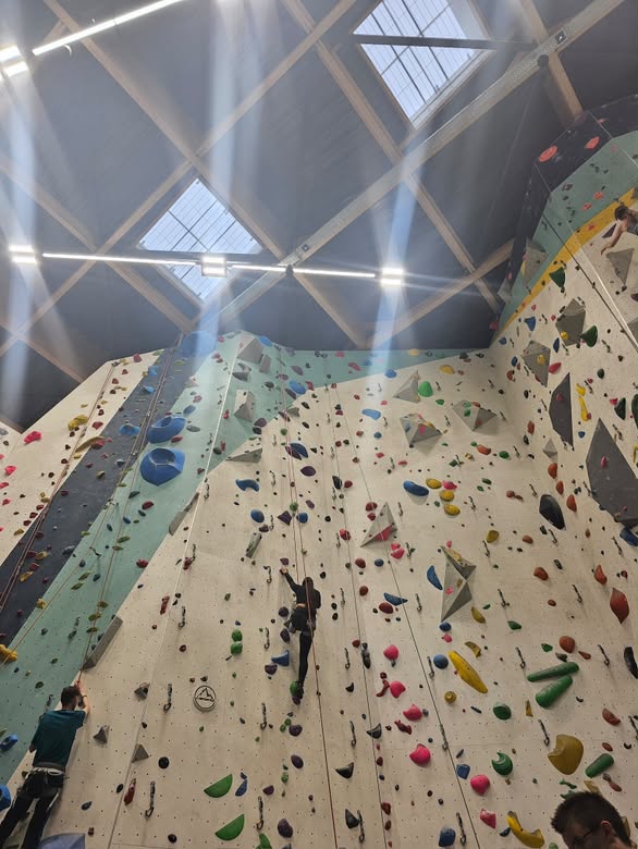 Muro de escalada interior con varias personas