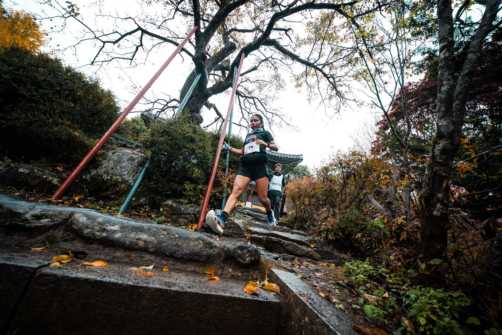 Miriam Morales desciende escalones de piedra en una zona boscosa del recorrido de Muju.