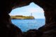 Portocolom Lighthouse on a cliff seen from a cave.