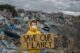 Small child holding placard poster on landfill, environmental pollution concept